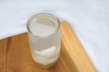 Fresh coconut juice in a glass with sweet coconut meat ,isolated on white background. Organic healthy drink concept.