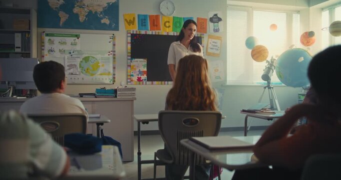 STEM Class on Renewable Energy: Female Teacher Educating Ecology to Diverse Elementary School Children. Talented Girl Talking, Presenting Homework in Front of Classroom Full of Classmates. Dolly Shot. - Powered by Adobe