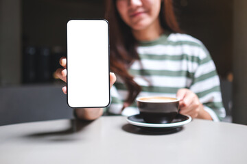 Mockup image of a woman holding and showing a mobile phone with blank white screen