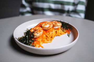 A plate of spicy shrimp spaghetti on dining table