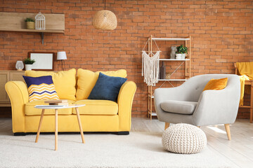 Interior of living room with yellow sofa, armchair and table