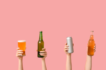 Female hands with fresh beer in can, pint and bottles on pink background