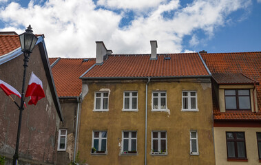 Fototapeta premium white and red flag and the facade of the tenement house in Reszel