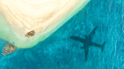 Aerial view of shadow passenger plane silhouette and sandy beach blue sea with waves at sea beach summer vacation sea travel concept	