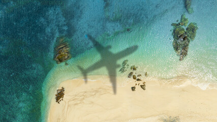 Aerial view of shadow passenger plane silhouette and sandy beach blue sea with waves at sea beach summer vacation sea travel concept	