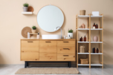 Blurred view of shelving unit with sink, mirror and pots of lavender flowers in modern bathroom