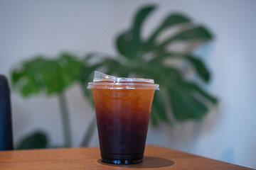 Close-up of Americano ice coffee or black coffee in cup mug on  wood desk office desk in coffee shop at the cafe in garden,during business work concept