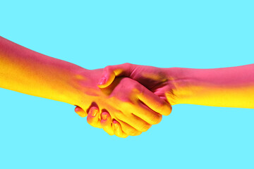 Toned women shaking hands on blue background