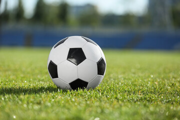 Fototapeta premium Soccer ball on green stadium grass, closeup