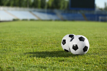 Obraz premium Soccer balls on green stadium grass