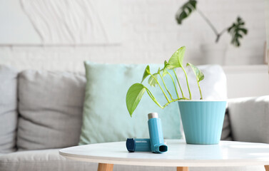 Modern inhaler and houseplant on coffee table in living room, closeup