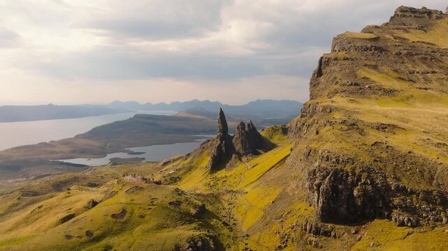 Aerial drone footage of the dramatic mountain landscapes and Old man of Storr on the Isle of Skye, Scotland. Sweeping panoramic views of majestic peaks, green valleys, and wild nature