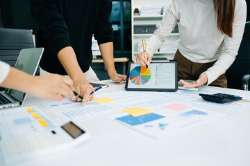 Business documents on office table with smart phone and calculator digital tablet and graph business with social network diagram and two colleagues discussing data working in the office