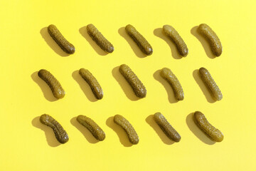 Texture of tasty pickled cucumbers on yellow background