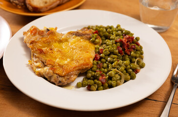 Delicious crispy chicken with peas as a side dish on a plate