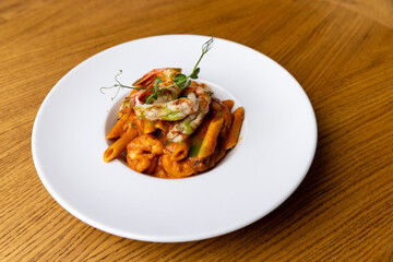 Juicy shrimps with penne pasta and creamy sauce served in a plate