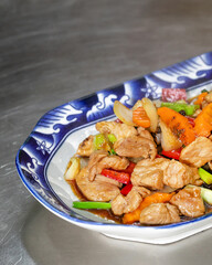 Succulent stir-fry chicken with vibrant vegetables, celebrating Qingming Festival balance and tantalizing Lunar New Year flavors on porcelain