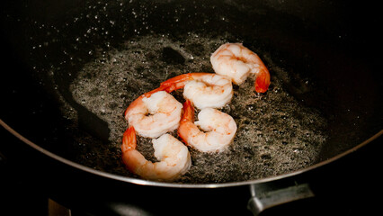 Seared shrimp sizzle in bubbly butter dance, echoing Mardi Gras feasts and lunar New Year seafood traditions