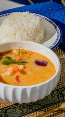 Creamy tom yum soup symphony beside jasmine rice, Thai culinary embrace, Loy Krathong festival, tantalizing tropical zest, cultural tapestry