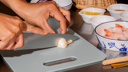 Chopping garlic under warm kitchen lights, culinary magic, Asian cuisine whispers, ready for Lunar New Year feasting