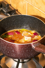 Simmering pot of vibrant vegetable stew, echoing flavors of Celtic Samhain and vegan comfort, cozy kitchen ambience unfolds