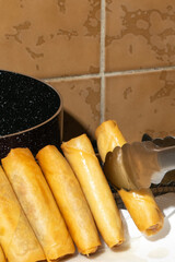 Golden spring rolls poised on a speckled plate, evoking Lunar New Year feasts, crispy culinary tradition, and savory delight