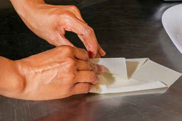 Crafting delicate pastry folds, Asian female hands whisper tales of Moon Festival traditions, evoking tangyuan reveries and cultural artistry