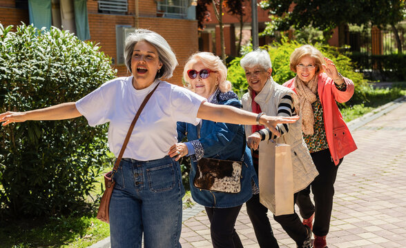 Group of women dancing playfully outdoors in a residential area