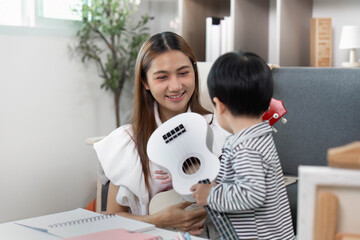 Creative Play. Child presenting a toy guitar to mother.