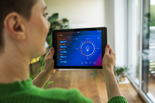 Woman at home controlling smarthome lighting system with tablet