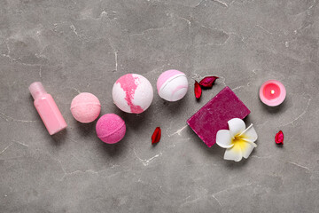 Bath bombs with soap, oil, candle and petals on grunge background