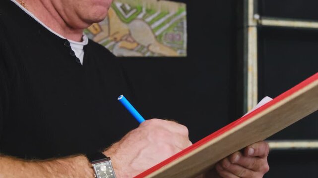 Man uses contour drawing technique using marker and sheet. Student learns to draw picture of mannequin and holds thin tool in hands gaining skills