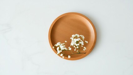 Oval wooden tray with delicate white flowers and gold accents on a light background