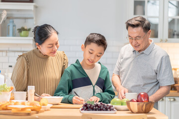 Joyful Asian grandparent, bonding at home lifestyle, warm moment of elderly couple enjoying coffee conversation while grandson stands together, cozy holiday kitchen with relaxed background atmosphere