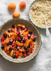 Cooking a summer dessert - berry crumble on a light background, top view