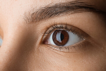 Obraz premium Young woman with brown eyes, closeup