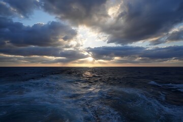 Stormy sky over the ocean with sunlight breaking through clouds