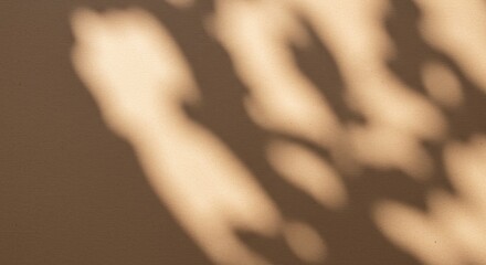 Abstract play of dappled sunlight and shadows on a light brown textured surface