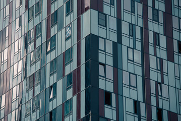empty glass windows of a modern building with a reflection of the sky in the glass