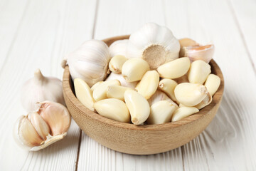 Bowl with fresh garlics on white wooden background, closeup