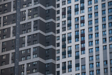 empty glass windows of a modern building with a reflection of the sky in the glass