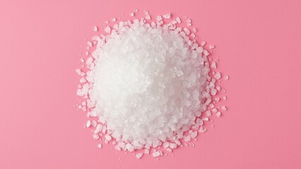 Magnesium Flakes. White coarse salt crystals macro close-up on pink ba