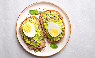 Avocado toast with boiled egg, sunflower seeds, pumpkin seeds and sesame seeds on plate, Healthy eating