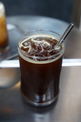 Close up glass of iced black Americano coffee with stainless steel straw