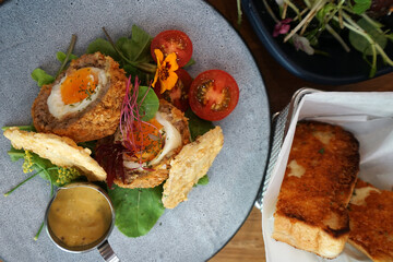Close up Scotch egg consists of a whole soft or hard-boiled egg wrapped in sausage meat, coated in bread crumbs and baked or deep-fried