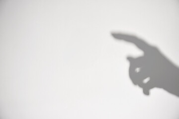 isolated person palm hand gesture gray shadow and arm silhouette black shade on white wall background