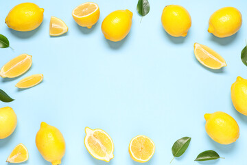 Frame made of fresh ripe lemons and leaves on blue background