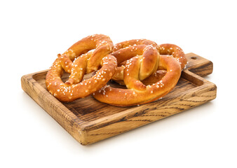 Wooden board with tasty salted pretzels on white background