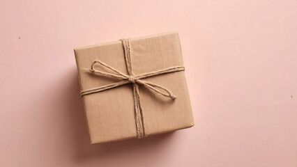 Kraft-wrapped gift with jute string on soft blush background