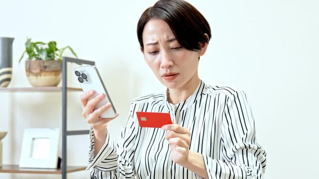 携帯とカードを持つ女性